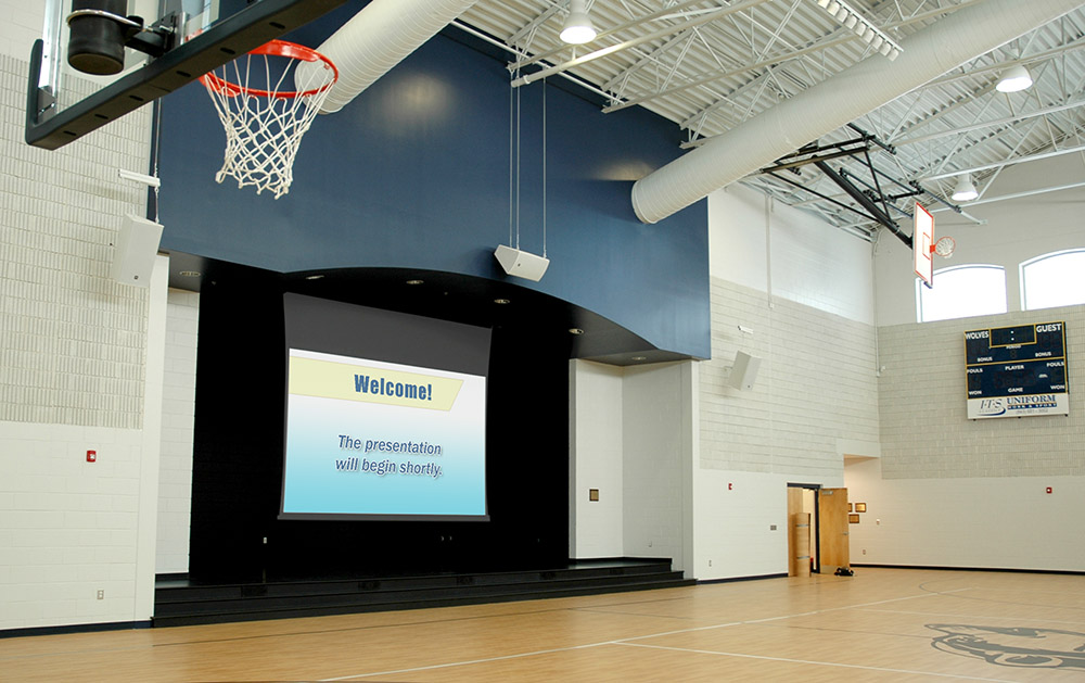 Projector system installed on the stage of a local school gymnasium